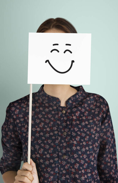 женщина покрывает лицо бумажным флагом
