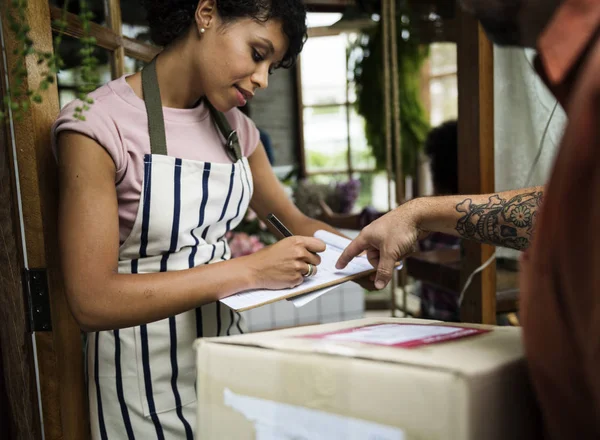 Mujer africana en delantal trabajando en tienda —  Fotos de Stock