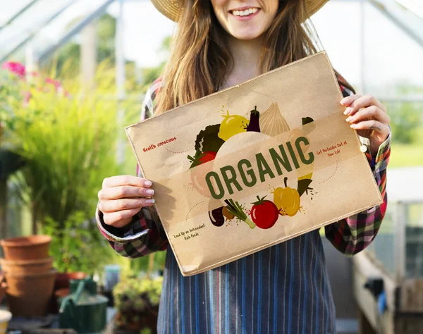 Woman holding paper banner in greenhouse — Stock Photo, Image