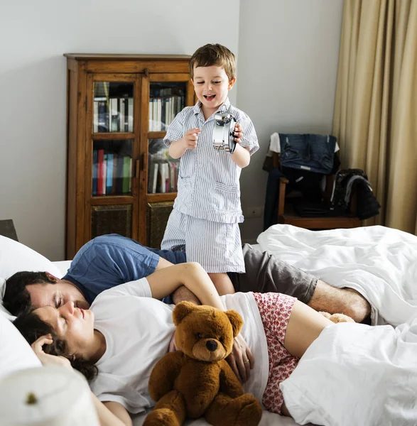 Chico despierto en dormitorio con padres — Foto de Stock