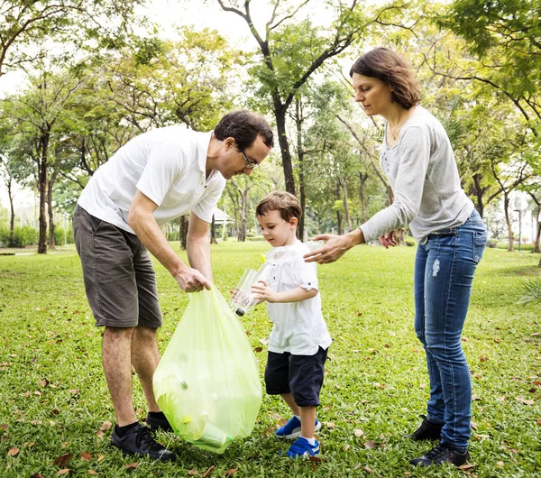 Родители с сыном уборка парка — стоковое фото
