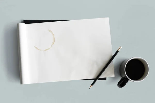 Kaffekopp och tom anteckningsbok — Stockfoto