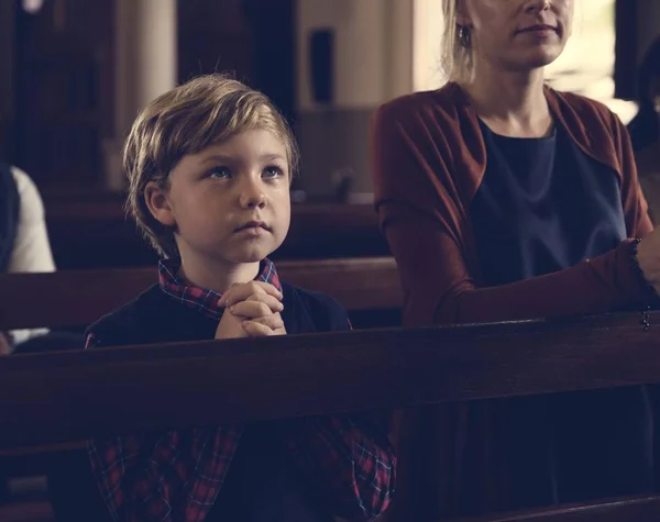 Chłopiec, modląc się w kościele — Zdjęcie stockowe