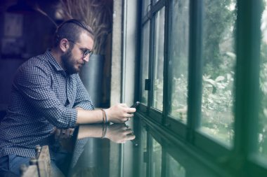 Pencere cep telefonu kullanan adam