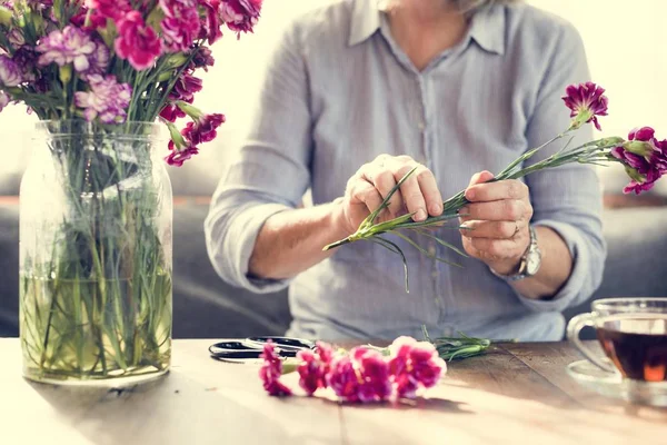 Mujer mayor cortando flores — Foto de Stock