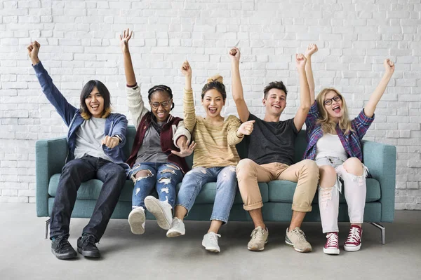 Estudantes felizes sentados no sofá — Fotografia de Stock