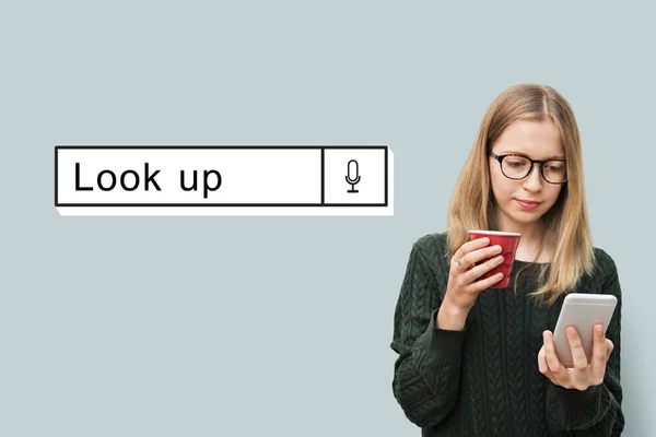 Mujer sosteniendo taza y usando el teléfono —  Fotos de Stock