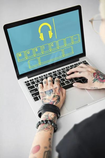 Tattooed person typing on laptop. — Stock Photo, Image