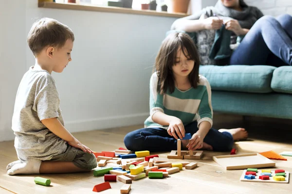 Crianças brincando no chão com brinquedos — Fotografia de Stock