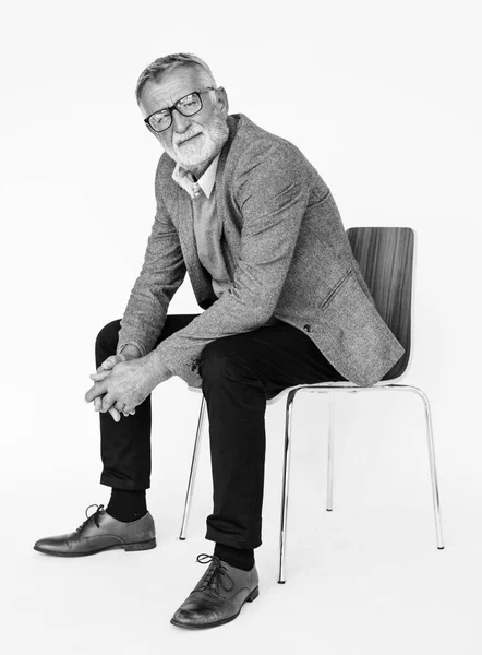 Uomo anziano in studio seduto sulla sedia — Foto Stock