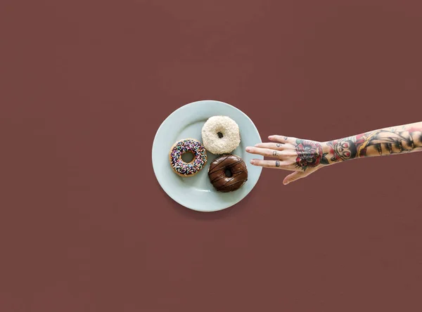 Hand att nå för donut — Stockfoto