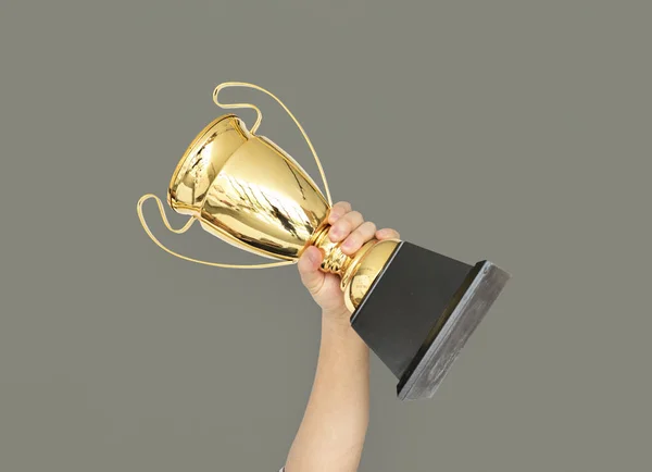 Hand holding golden trophy — Stock Photo, Image