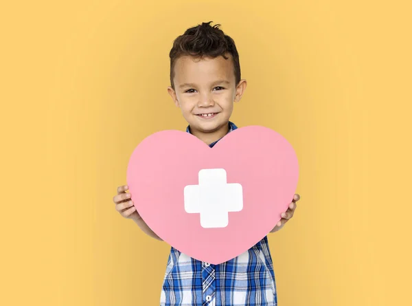 Niño sosteniendo el corazón con cruz —  Fotos de Stock