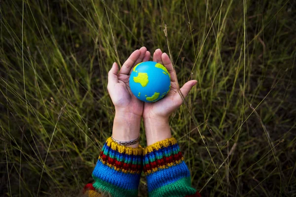 Mãos segurando pequeno globo — Fotografia de Stock