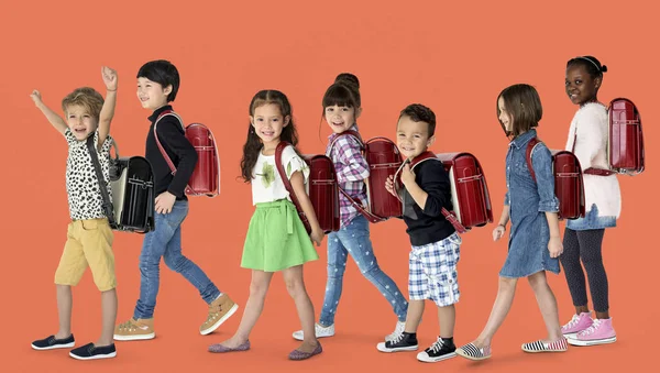 Crianças caminhando para a escola com mochilas — Fotografia de Stock