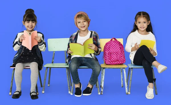 Dzieci siedząc na krzesłach z książek — Zdjęcie stockowe
