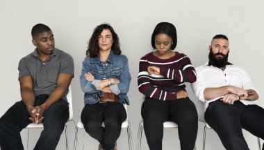 Sandalye üzerinde oturan ve bekleyen insanlar