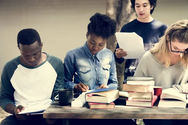 Students brainstorming with books — Stock Photo, Image