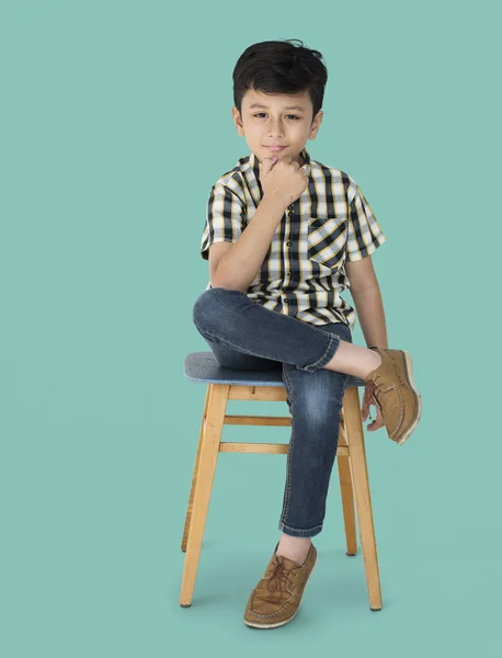 Pojken sitter på stolen — Stockfoto