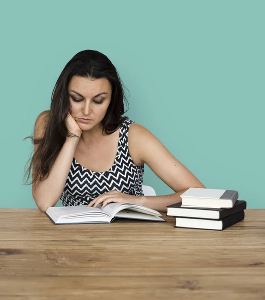 Mulher lendo livros enquanto sentado à mesa — Fotografia de Stock