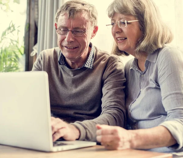 Ηλικιωμένο ζευγάρι που χρησιμοποιεί φορητό υπολογιστή — Φωτογραφία Αρχείου