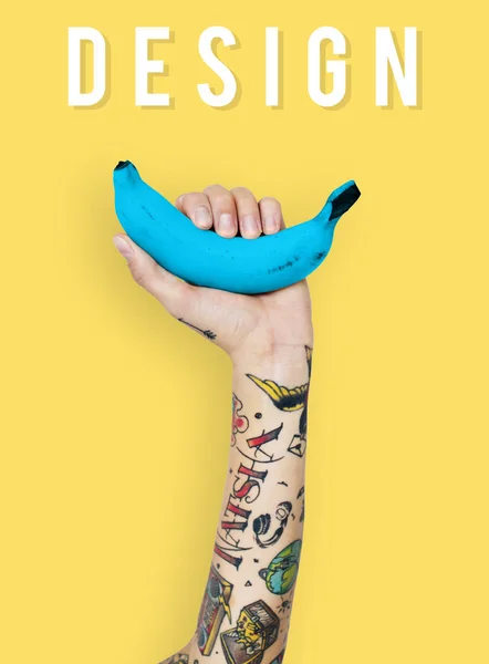 Pessoa tatuada segurando banana . — Fotografia de Stock