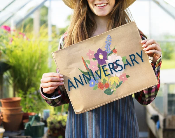 Frau hält Papierbanner im Gewächshaus — Stockfoto