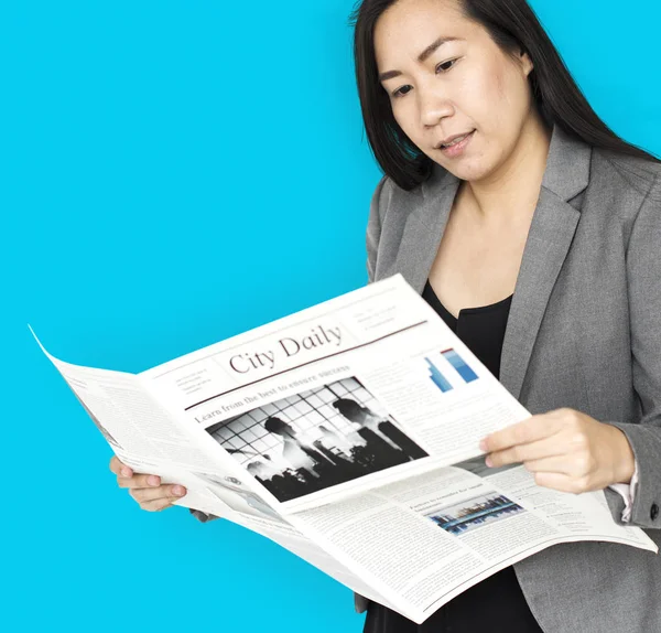 Азиатская женщина читает газету — стоковое фото