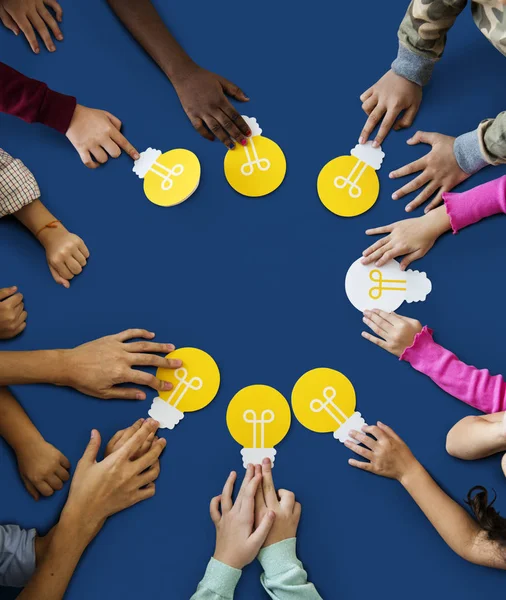 Children hands holding light bulbs — Stock Photo, Image