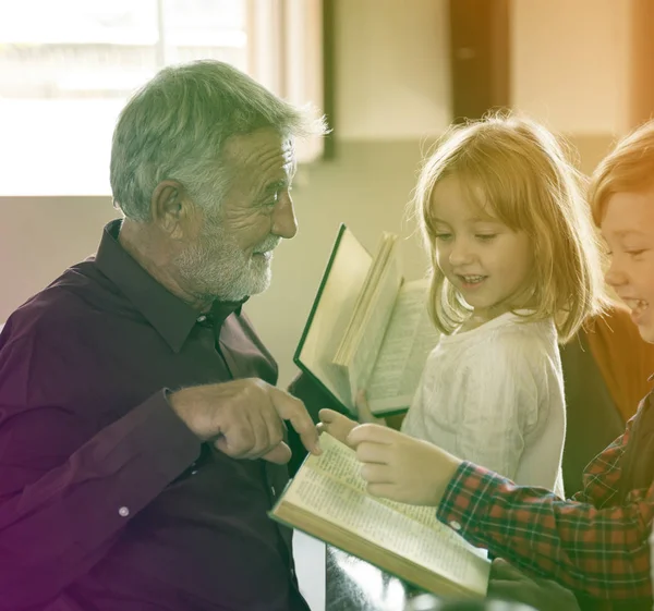 Prêtre montrant la Bible aux enfants — Photo