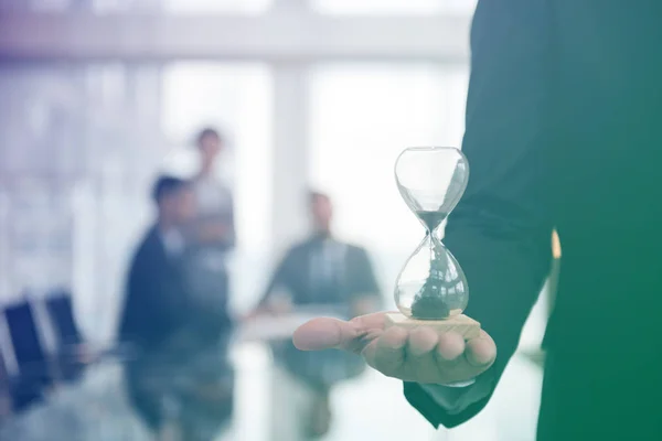 Hombre de negocios sosteniendo reloj de arena — Foto de Stock