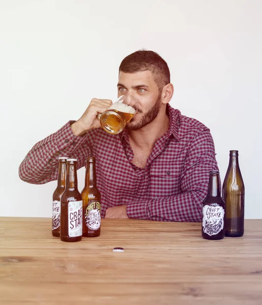 Uomo bere birra mentre seduto — Foto Stock