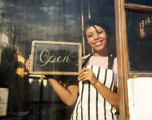 African woman in apron working in shop — Stock Photo, Image