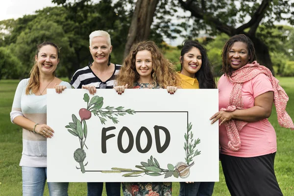 Cinco mulheres sorridentes segurando banner — Fotografia de Stock