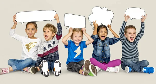 Niños sosteniendo burbujas del habla — Foto de Stock