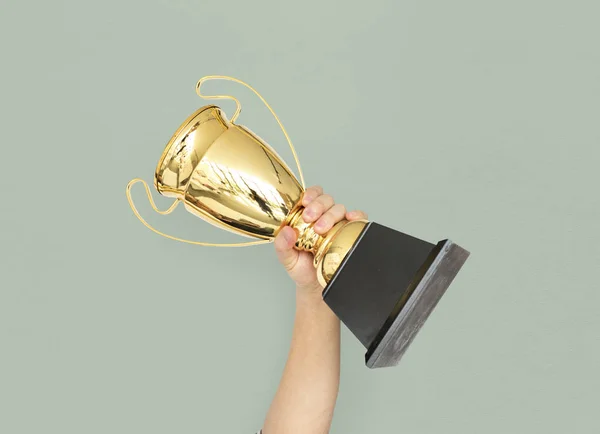 Mão segurando troféu dourado — Fotografia de Stock