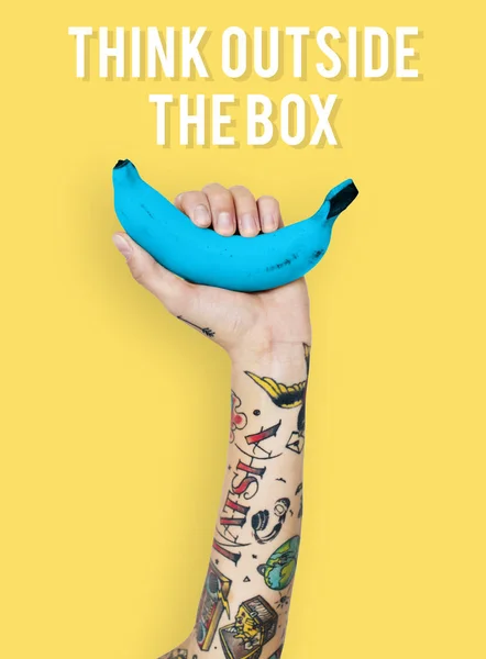 Tattooed person holding banana. — Stock Photo, Image