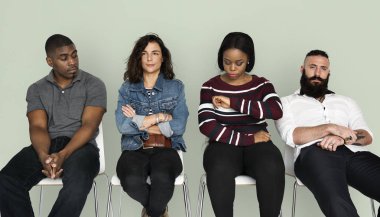 Sandalye üzerinde oturan ve bekleyen insanlar