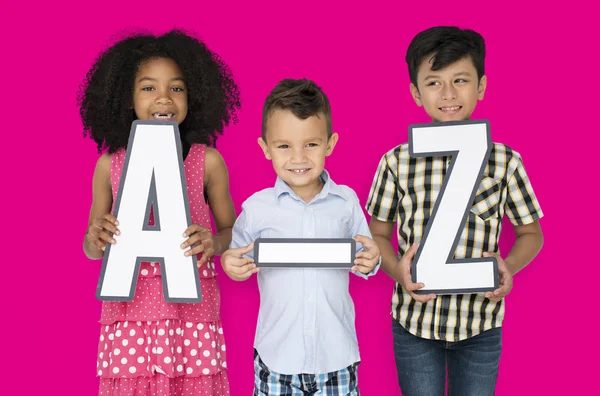 Niños sosteniendo cartas de papel A-Z —  Fotos de Stock