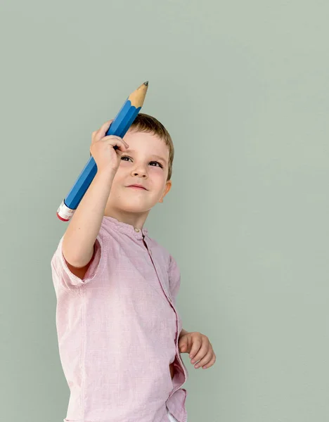 Chłopiec trzyma duży ołówek — Zdjęcie stockowe