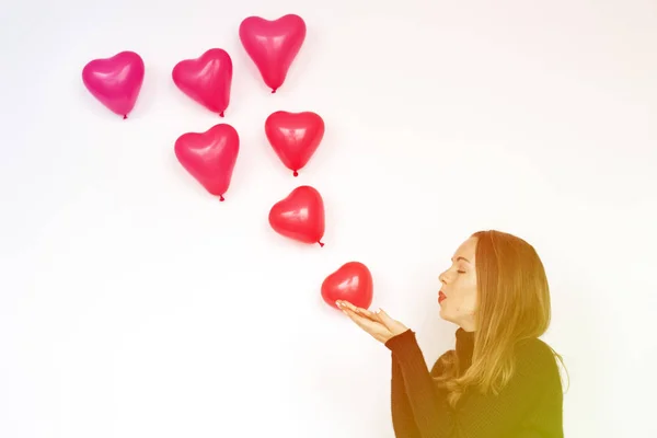 Femme soufflant ballons coeur — Photo