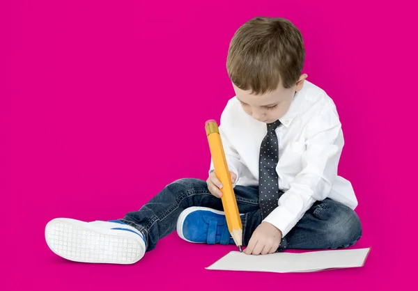 Junge schreibt mit großem Bleistift — Stockfoto