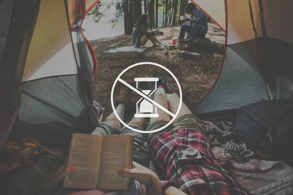Casal deitado na tenda e livro de leitura — Fotografia de Stock