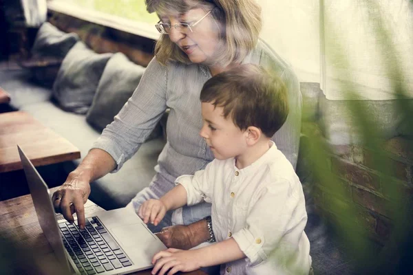 Mormor och barnbarn använder laptop — Stockfoto
