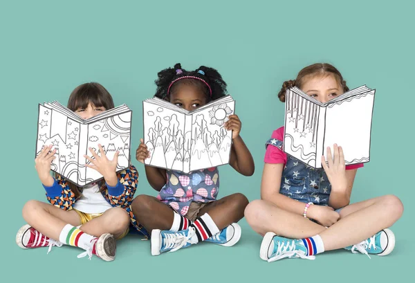 Meninas cobrindo rostos com livros — Fotografia de Stock