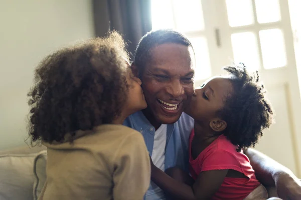 Дочери целуют отца — стоковое фото