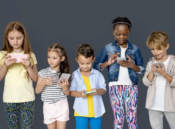 Crianças usando smartphones em estúdio — Fotografia de Stock