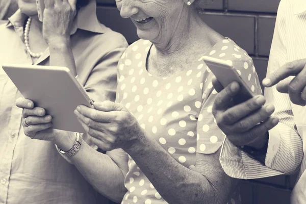 Pessoas idosas navegando dispositivos digitais — Fotografia de Stock