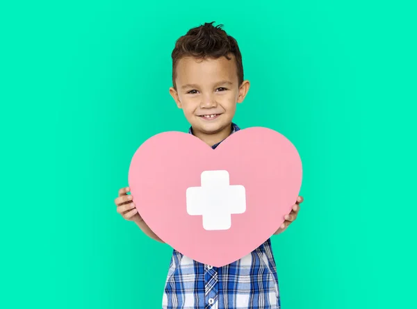 Хлопчик тримає серце з хрестом — стокове фото