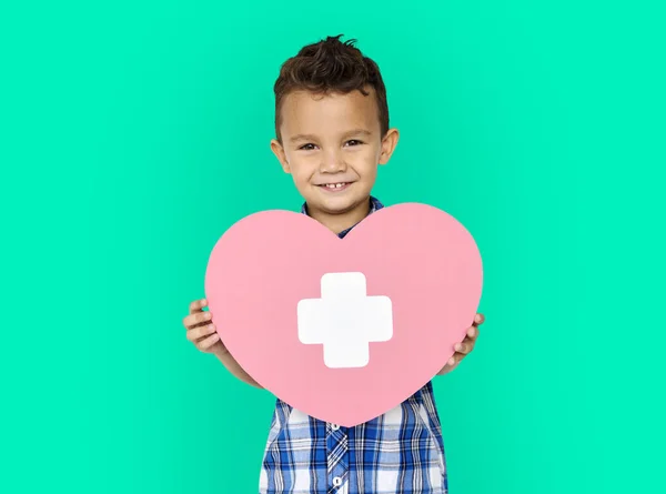 Jongen bedrijf hart met kruis — Stockfoto